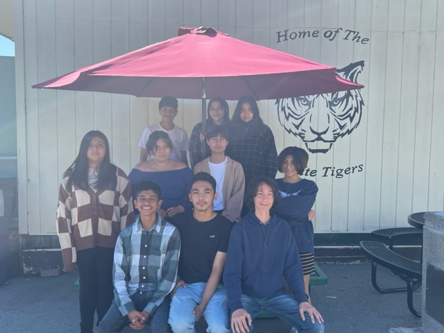 The Associated Student Body group photo under an umbrella